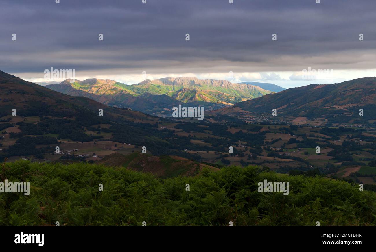 Berglandschaft, grünes Tal auf dem Weg des Heiligen James in den französischen Pyrenäen. Wolken, die über den Berggipfeln schweben. Querformat auf dem Stockfoto