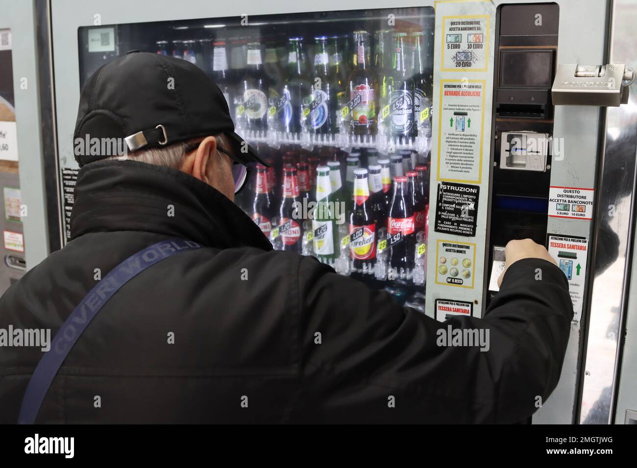 Ein Mann kauft einen Drink aus einem 24h-Automaten Stockfoto
