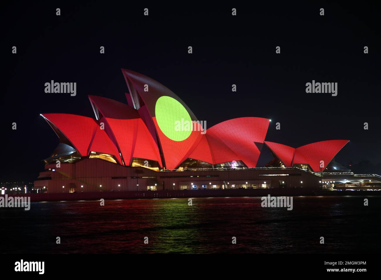 Sydney, Australien. 26. Januar 2023 Die Segel des Opernhauses von Sydney wurden anlässlich des Australientages mit einheimischen Kunstwerken beleuchtet. Die Kunstwerke der Kamilaroi-Frau Rhonda Sampson wurden auf die Segel des Opernhauses sowie auf die australischen und Aborigines-Flaggen projiziert. Im Bild: Die Aborigines-Flagge. Kredit: Richard Milnes/Alamy Live News Stockfoto