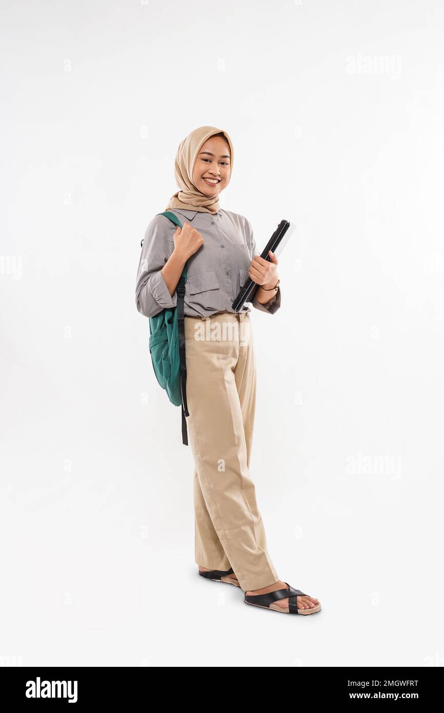 Ein Schüler mit Hidschab bringt die grüne Tasche und das Telefon Stockfoto