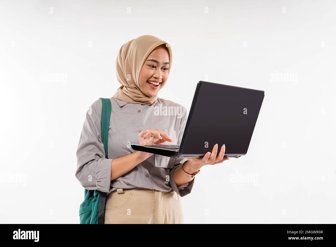 Eine Studentin mit einem lächelnden Hijab, während sie den Laptop öffnete Stockfoto