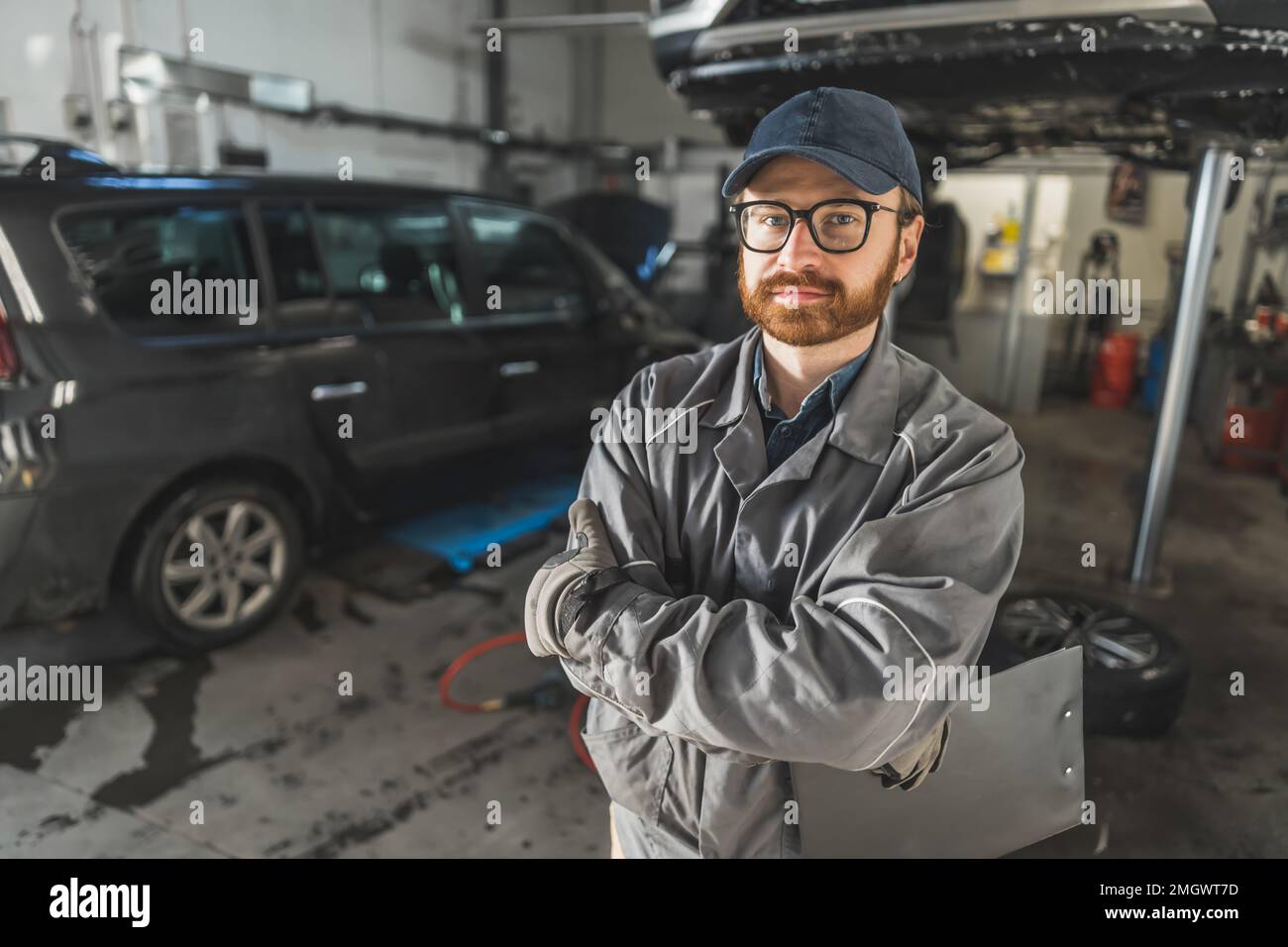 Porträt eines Automechanikers mit schwarzem Klemmbrett in einer Kfz-Reparaturwerkstatt. Hochwertiges Foto Stockfoto