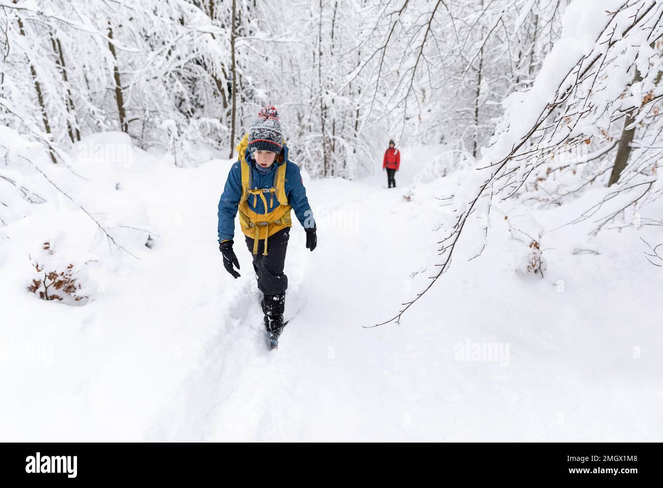 Mutter und Sohn, Touristen, auf einer Wanderung mit der Familie, Wandern in einem tiefen Schnee im Schneesturm im Wald von Kocevski rog in Dolenjska Region, Slowenien Stockfoto