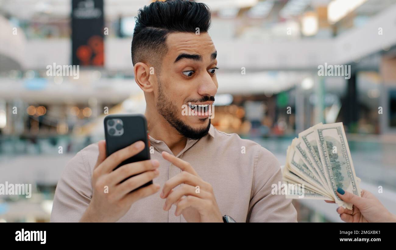 Gewinner eines indischen Mannes, männlicher Kerl, der mit dem Telefon surft, online wettet, Casino spielt Bezahlung mit Smartphone-App-Zahlungsservice Guthaben einfaches Geld erstaunlich Stockfoto