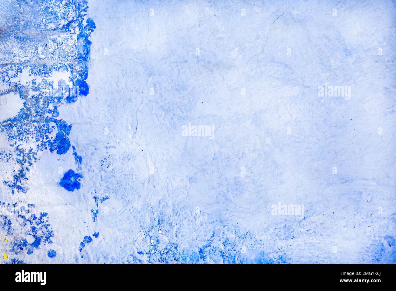 Ein einfaches Hintergrund- oder Tischbild. Das Foto zeigt eine raue gerenderte Wand. Weiß und blau mit mediterranem Flair Stockfoto