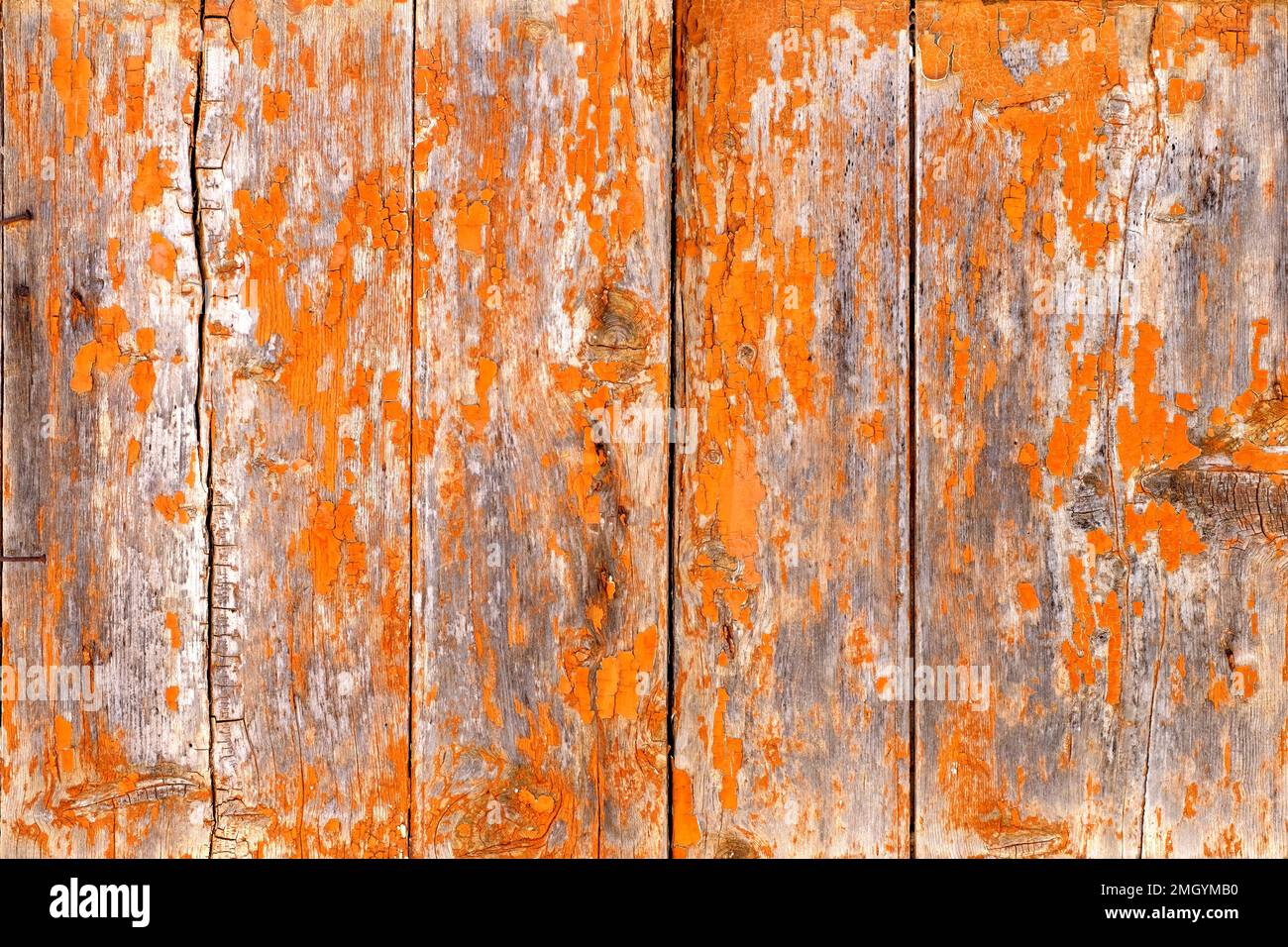 Ein einfaches Hintergrund- oder Tischbild. Das Foto zeigt eine abgenutzte rustikale Holztafel, orange gestrichen. Die Witterung hat die Farbe aufgeweicht Stockfoto