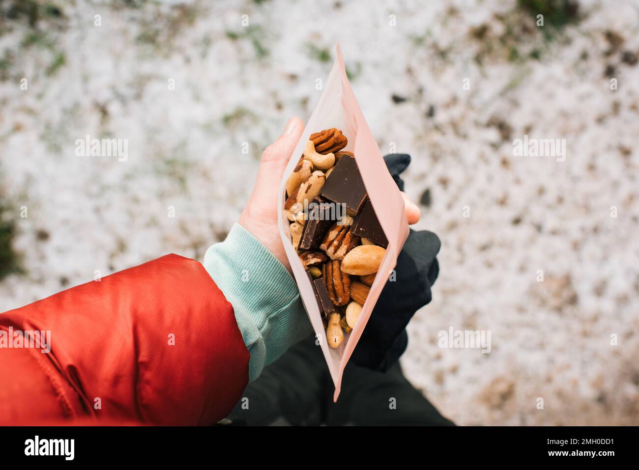 Frau, die beim Wandern Trail Mix in einer wiederverwendbaren Snacktasche hält Stockfoto