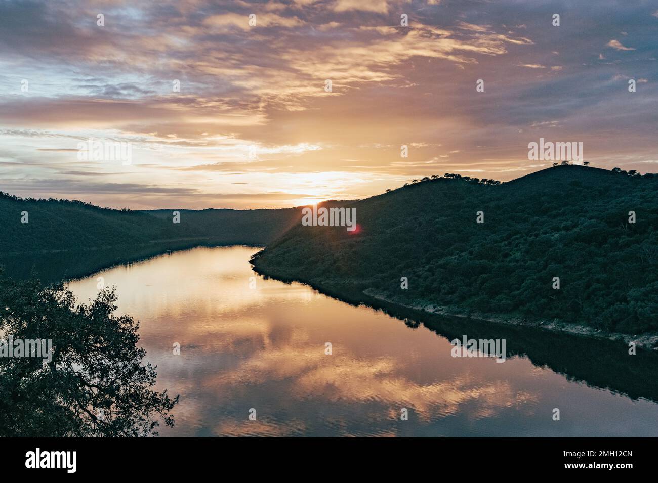 Fluss bei Sonnenuntergang mit Reflexionen des Himmels im Naturpark Monfrague in Caceres in Spanien Stockfoto