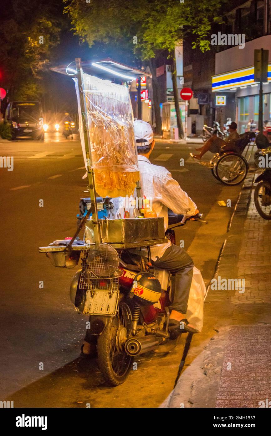 Zurück von einem Fischverkäufer auf einem Motorrad, das nachts in Hanoi Moped Stockfoto