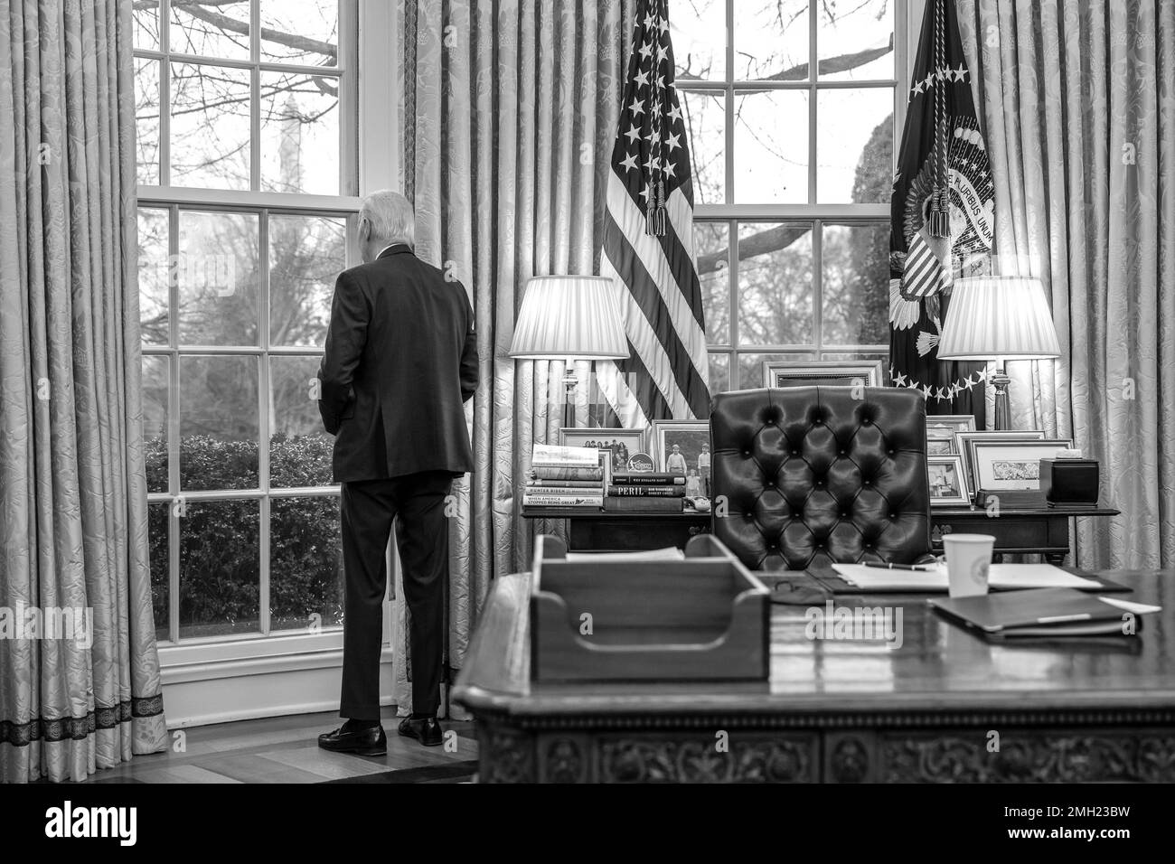 Präsident Joe Biden blickt während eines Telefonats mit Bundeskanzler Olaf Scholz vom Dienstag, den 17. Januar 2023, im Oval Office aus dem Fenster. (Offizielles Foto des Weißen Hauses von Adam Schultz) Stockfoto