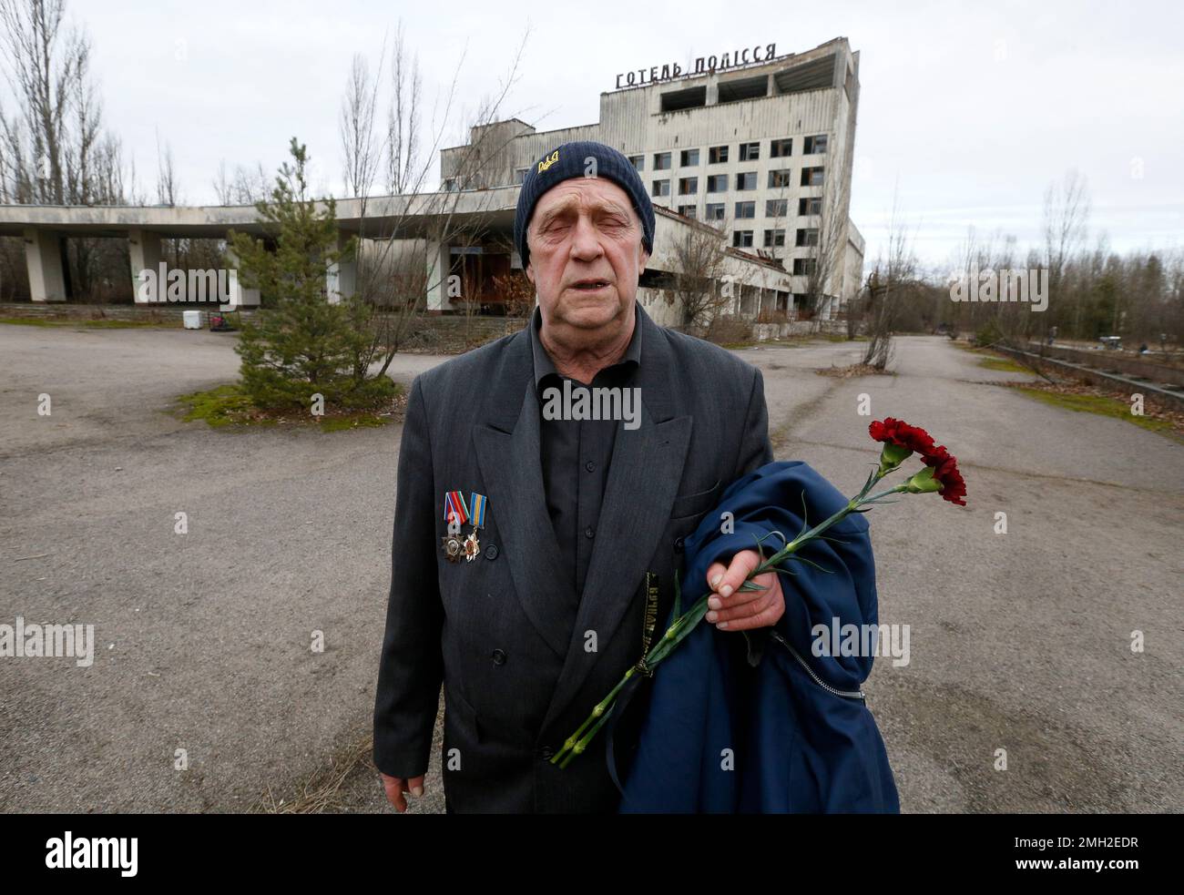 Former resident of Pripyat, Olexander Zabelchenko holds flowers as he celebrates the 50th anniversary of the city in a central square of the abandoned city of Pripyat, not far from the Chernobyl nuclear power station, Ukraine, Tuesday, Feb. 4, 2020. It was the first time some former residents had returned to the city since their evacuation after the world's worst nuclear accident. (AP Photo/Efrem Lukatsky) Stockfoto