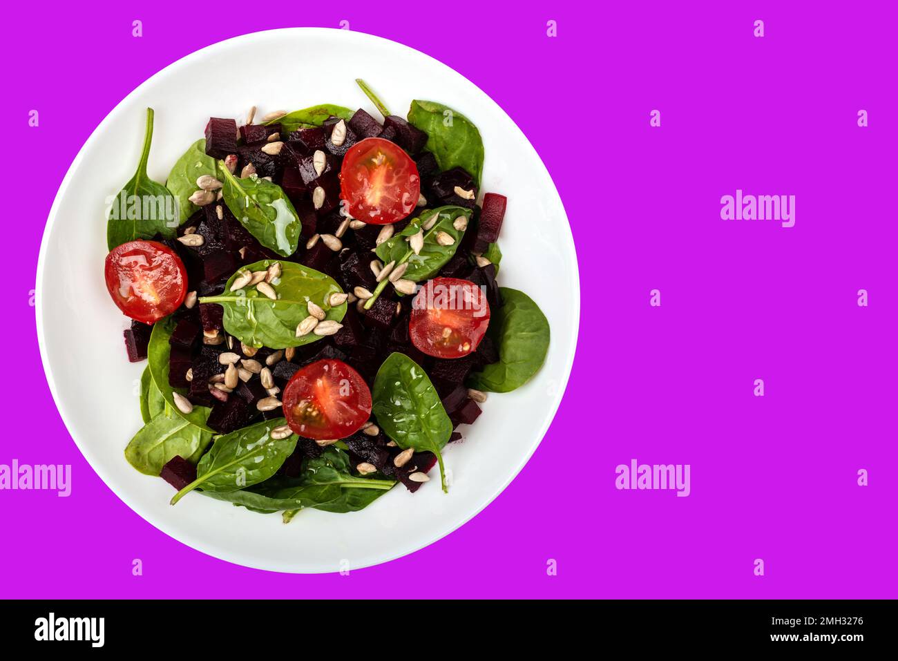 Salat mit Rote-Bete-Spinat Kirschtomaten und Samen gesunde vegetarische Speisen auf isoliertem Hintergrund Stockfoto