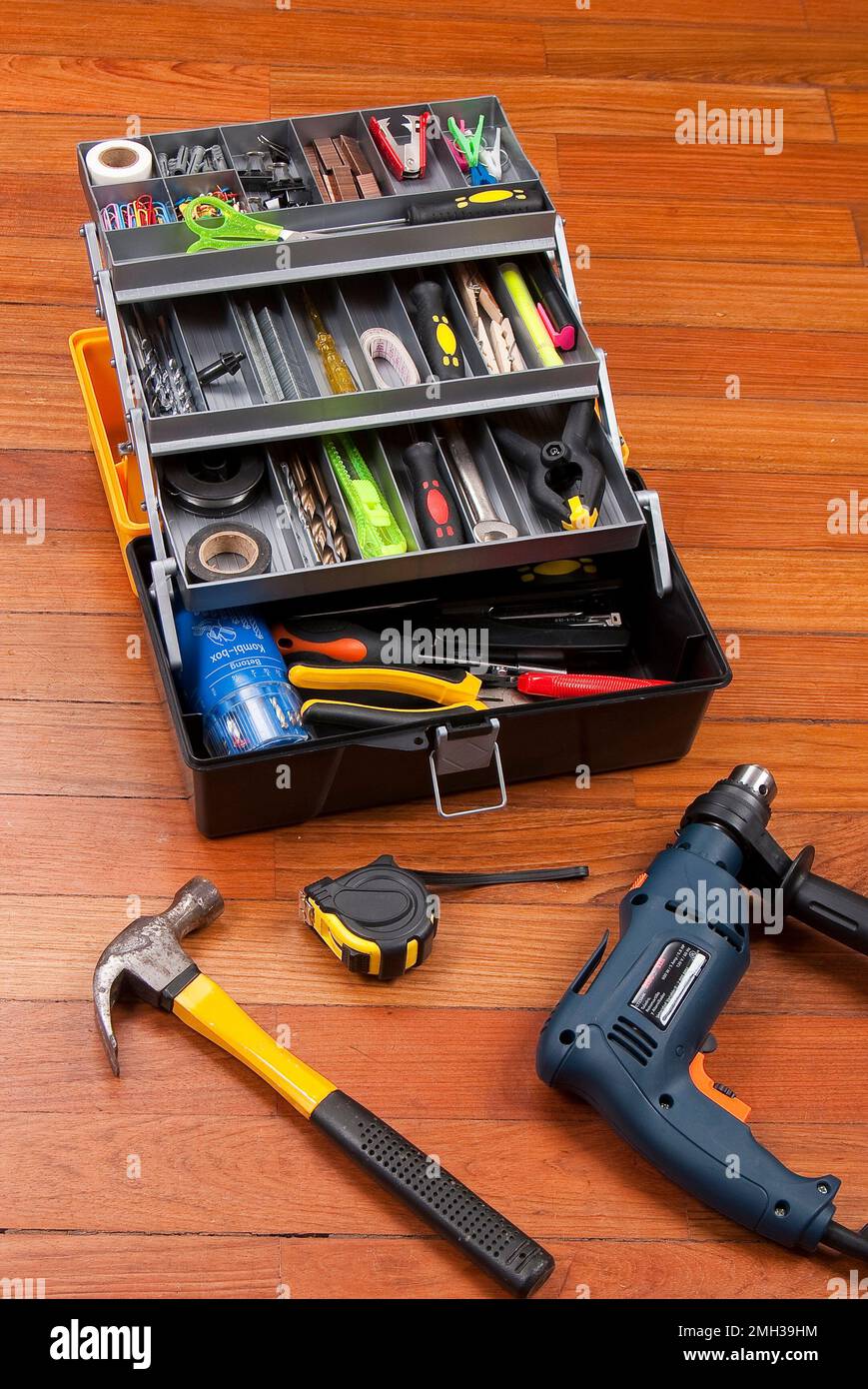 Kunststoffbox zum Organisieren von Werkzeugen; Foto auf Holzhintergrund. Stockfoto