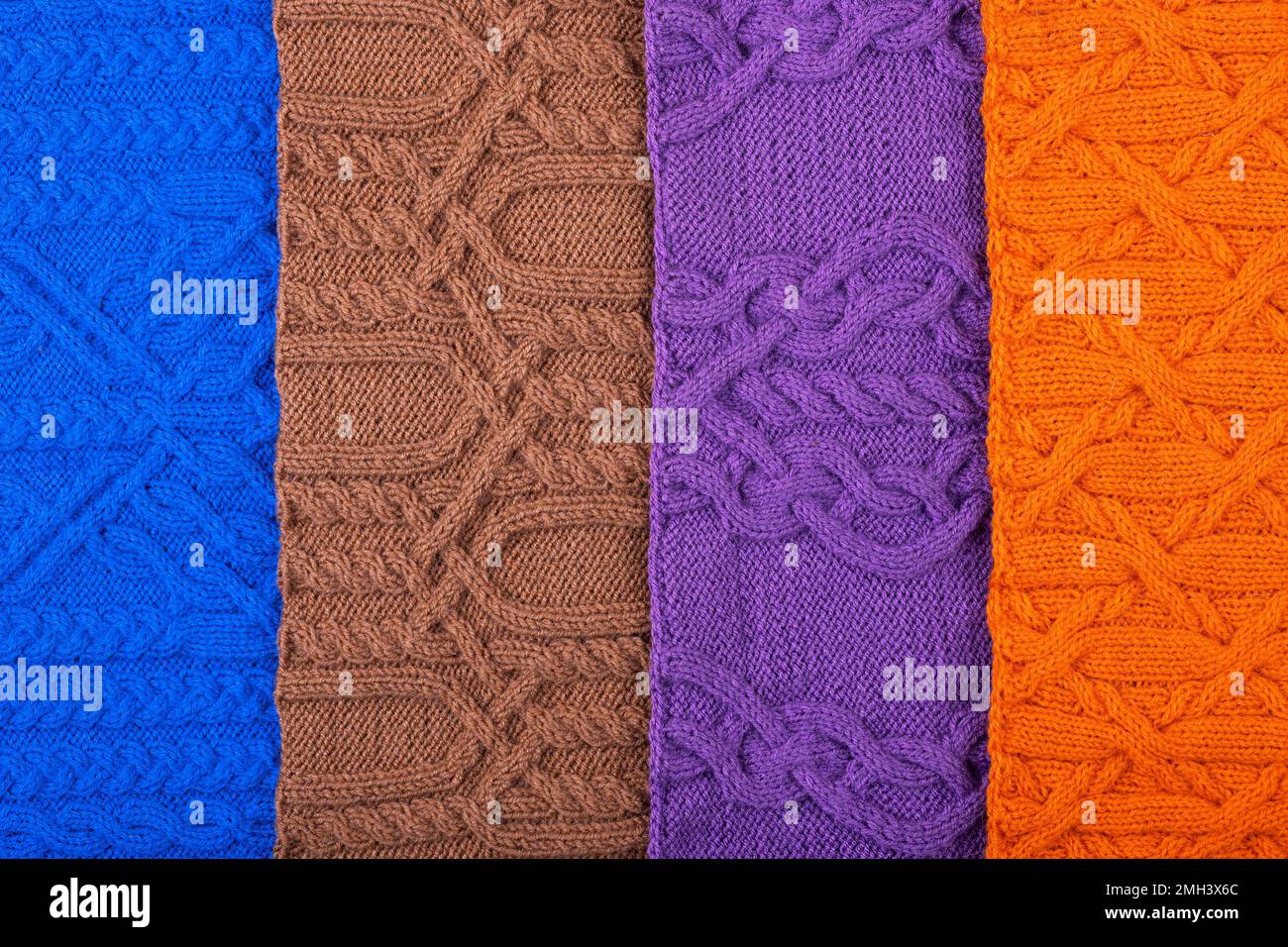 Gestrickter Hintergrund: Blau, lila, braun und orange. Großer Strickstoff mit Muster. Nahaufnahme einer Strickdecke. Stockfoto
