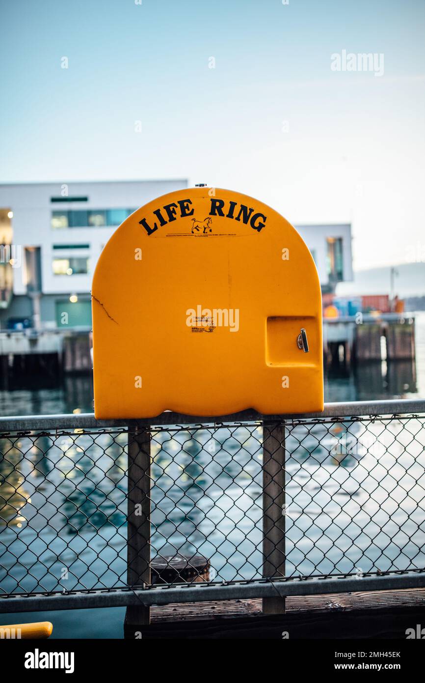 Yellow Life Ring Tough Guy Fiberglass Cabinet von Cheyenne Manufacturing an der Seattle Waterfront Stockfoto