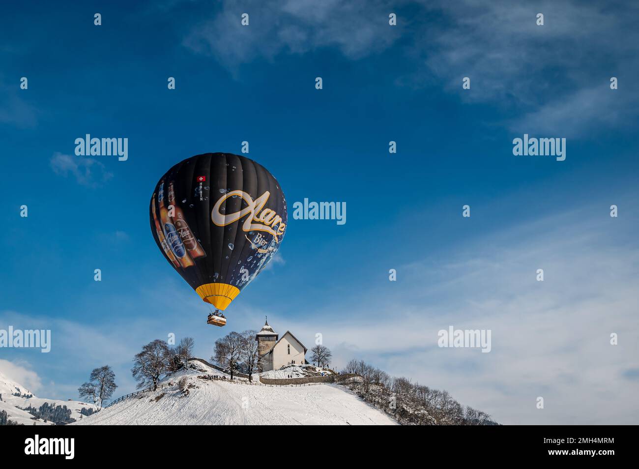 Chateau-d'Oex, Vaud, Schweiz - 23. Januar 2023: Heißluftballon. Aare Bier Heißluftballonfahrt am Himmel. Stockfoto