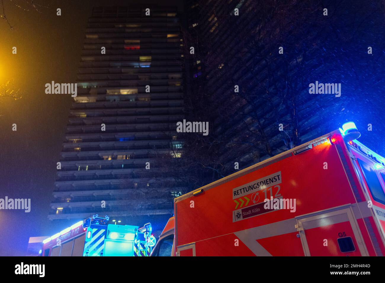 Köln, Deutschland. 26. Januar 2023. Feuerwehrleute stehen vor dem Uni-Center. Am Donnerstagabend brach im Uni-Center in Köln ein Feuer aus, das als eines der größten Wohngebäude Europas gilt. Mehrere Anrufer berichteten, dass sich Rauch auf alle 42 Stockwerke ausbreitete, sagte ein Sprecher der Feuerwehr. 50 bis 60 Bewohner wurden evakuiert, sagte er. Kredit: Rolf Vennenbernd/dpa/Alamy Live News Stockfoto