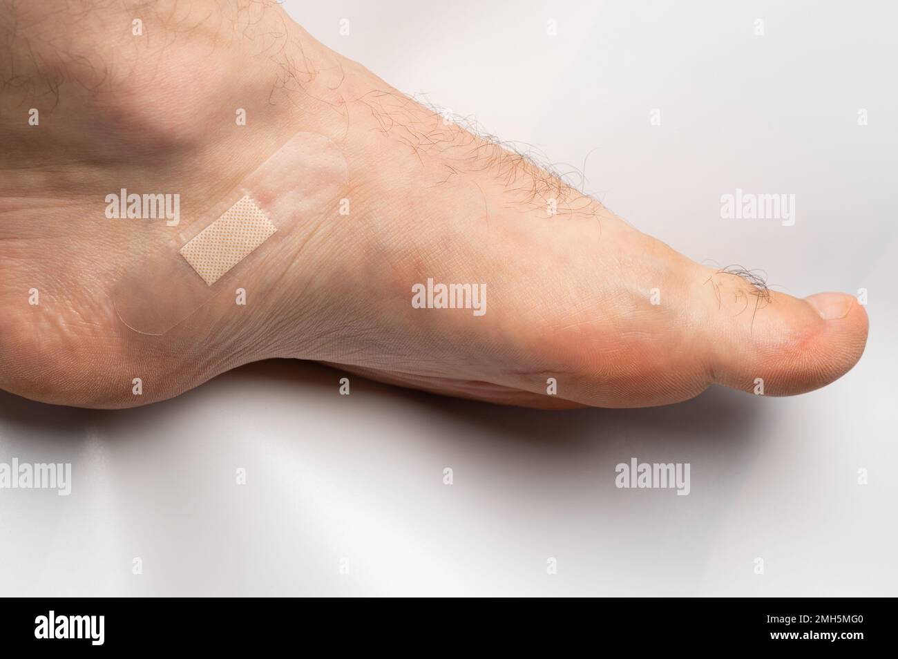 Medizinische Bandage am menschlichen Bein isoliert auf weißem Studiohintergrund Nahaufnahme Stockfoto