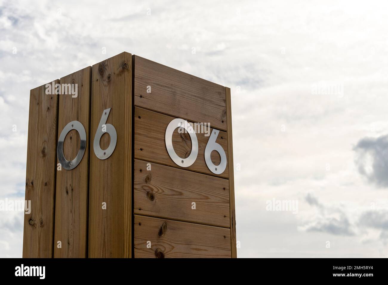 Die Nummer sechs aus Edelstahl auf einem Holzhintergrund am Himmel. 06 Stockfoto