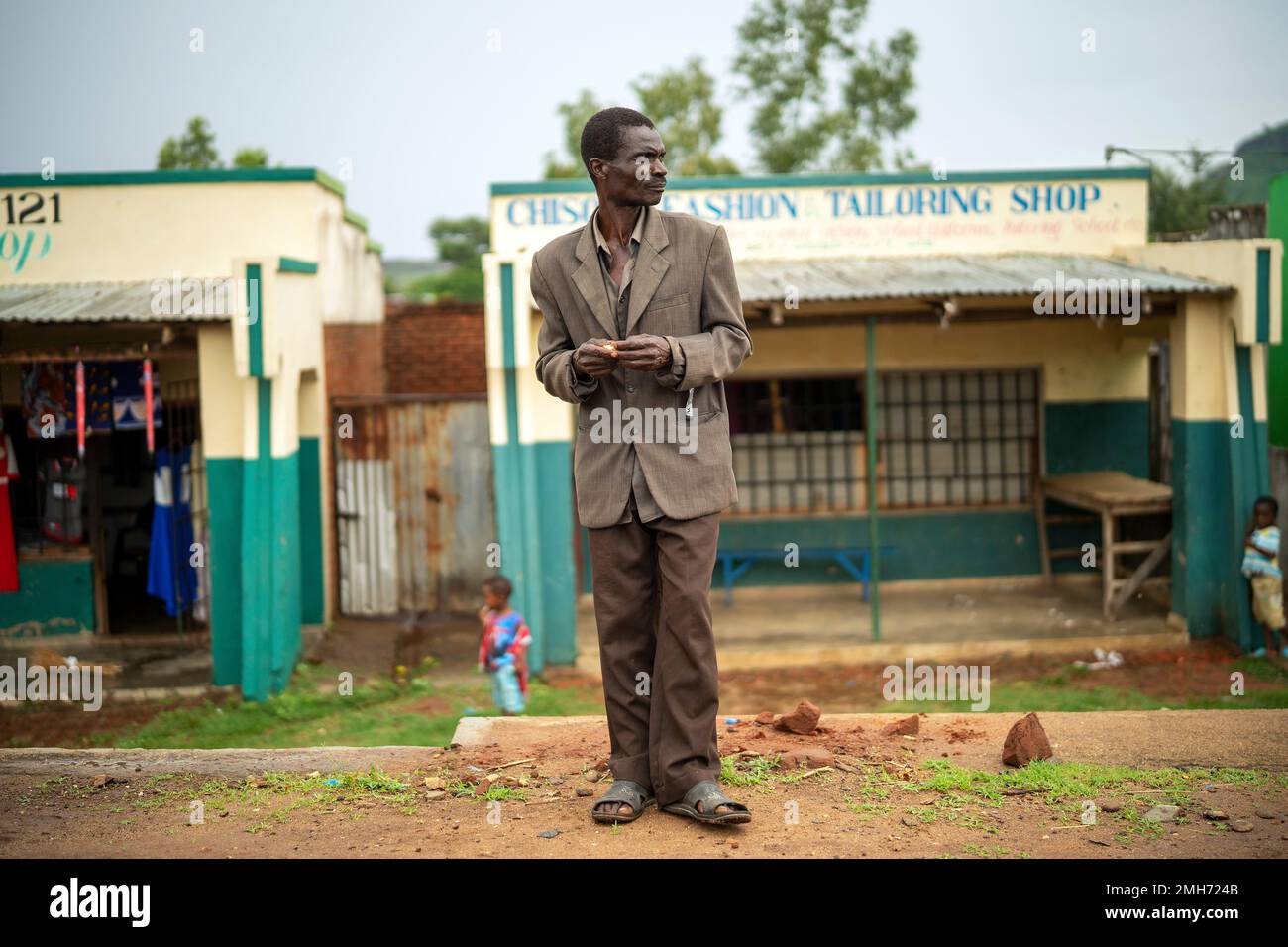 In this photograph taken Tuesday Dec. 10, 2019, A man stands outside the health clinic in the village of Migowi, Malawi. Malawi is rolling out an unusual pilot vaccination program against Malaria, one of history's deadliest and most stubborn disease. Parents in Malawi as well as Kenya and Ghana, are being asked to put faith in a series of injections that are only about 40% effective. (AP Photo/Jerome Delay) Stockfoto