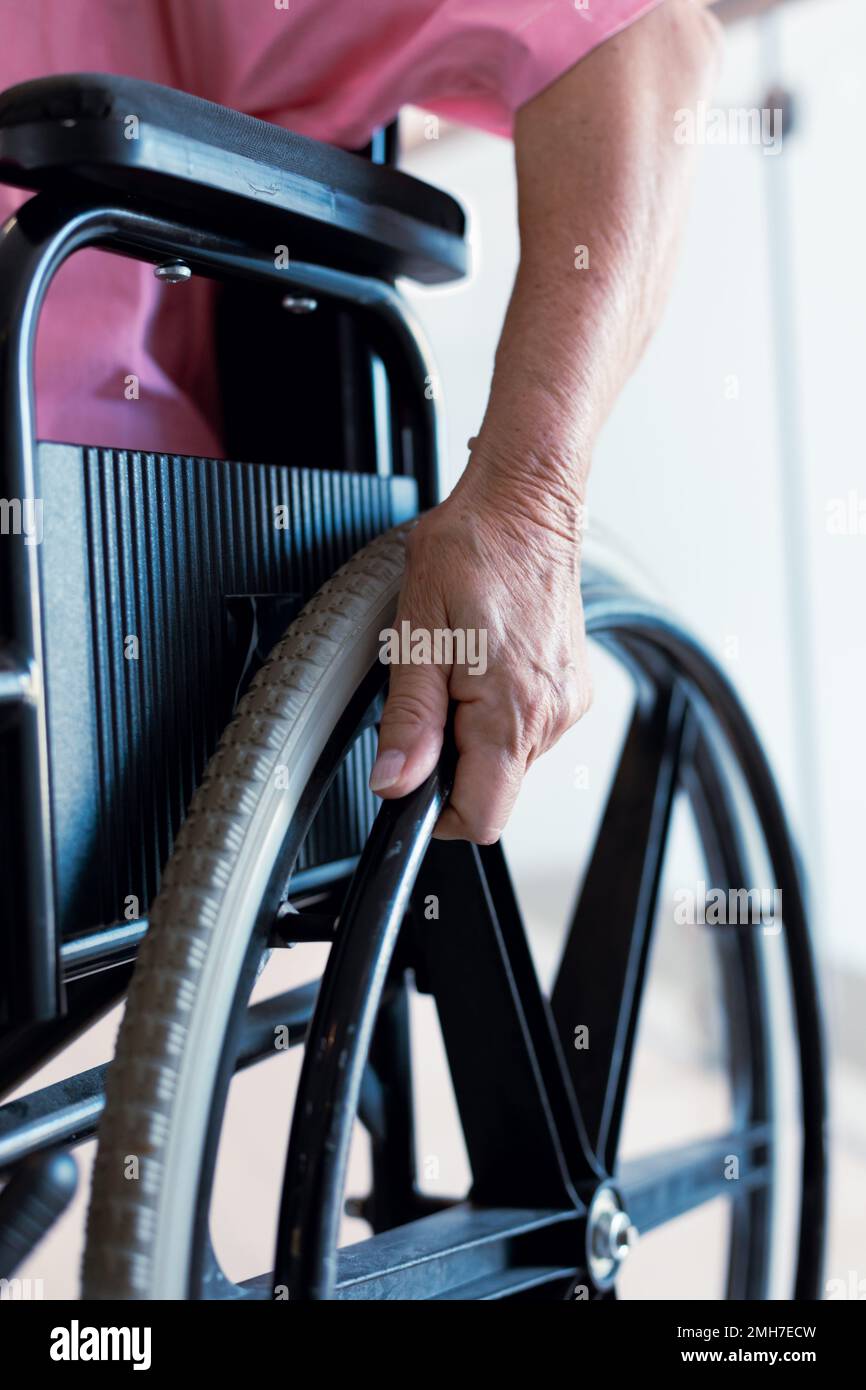 Nahaufnahme einer leitenden weissen Patientin im Rollstuhl im Krankenhaus Stockfoto