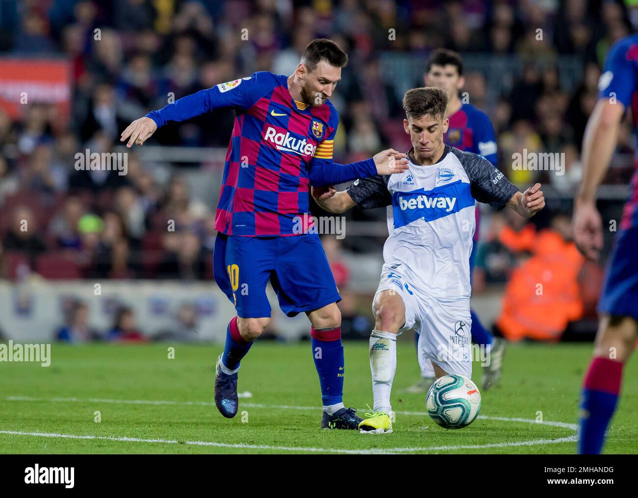 Barcelona's Lionel Messi, left, fights for the ball during a Spanish La Liga soccer match between Barcelona and Alaves at Camp Nou stadium in Barcelona, Spain, Saturday, Dec. 21, 2019. (AP Photo/Joan Monfort) Stockfoto