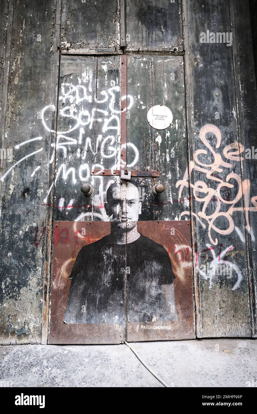 Ein Plakat aus Papier, das an der Vordertür eines alten Gebäudes klebte. Das Bild ist von einem jungen Mann. Ein Beispiel für Graffiti in Neapel, Neapel, Italien, Italien. Stockfoto