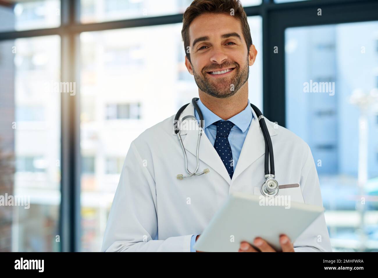 Mit der neuesten Technologie zu heilen. Porträt eines beschäftigten Arztes, der die Krankenakte eines Patienten auf seinem Tablet überprüft. Stockfoto