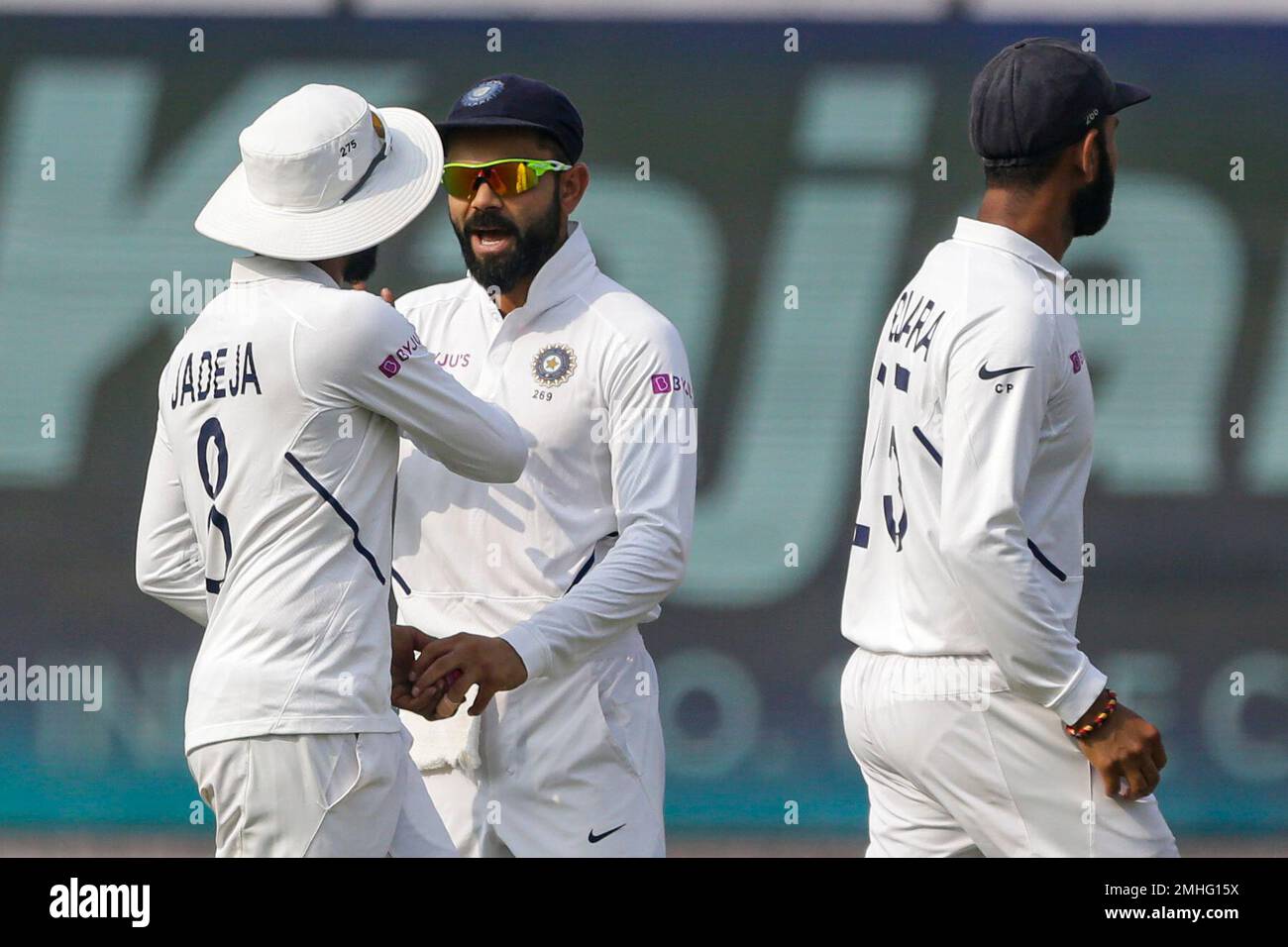 India's Virat Kohli, center, congratulates teammate Ravindra Jadeja for taking a catch to dismiss Bangladesh's Mushfiqur Rahim during the third day of the second test cricket match between India and Bangladesh, in Kolkata, India, Sunday, Nov. 24, 2019. (AP Photo/Bikas Das) Stockfoto