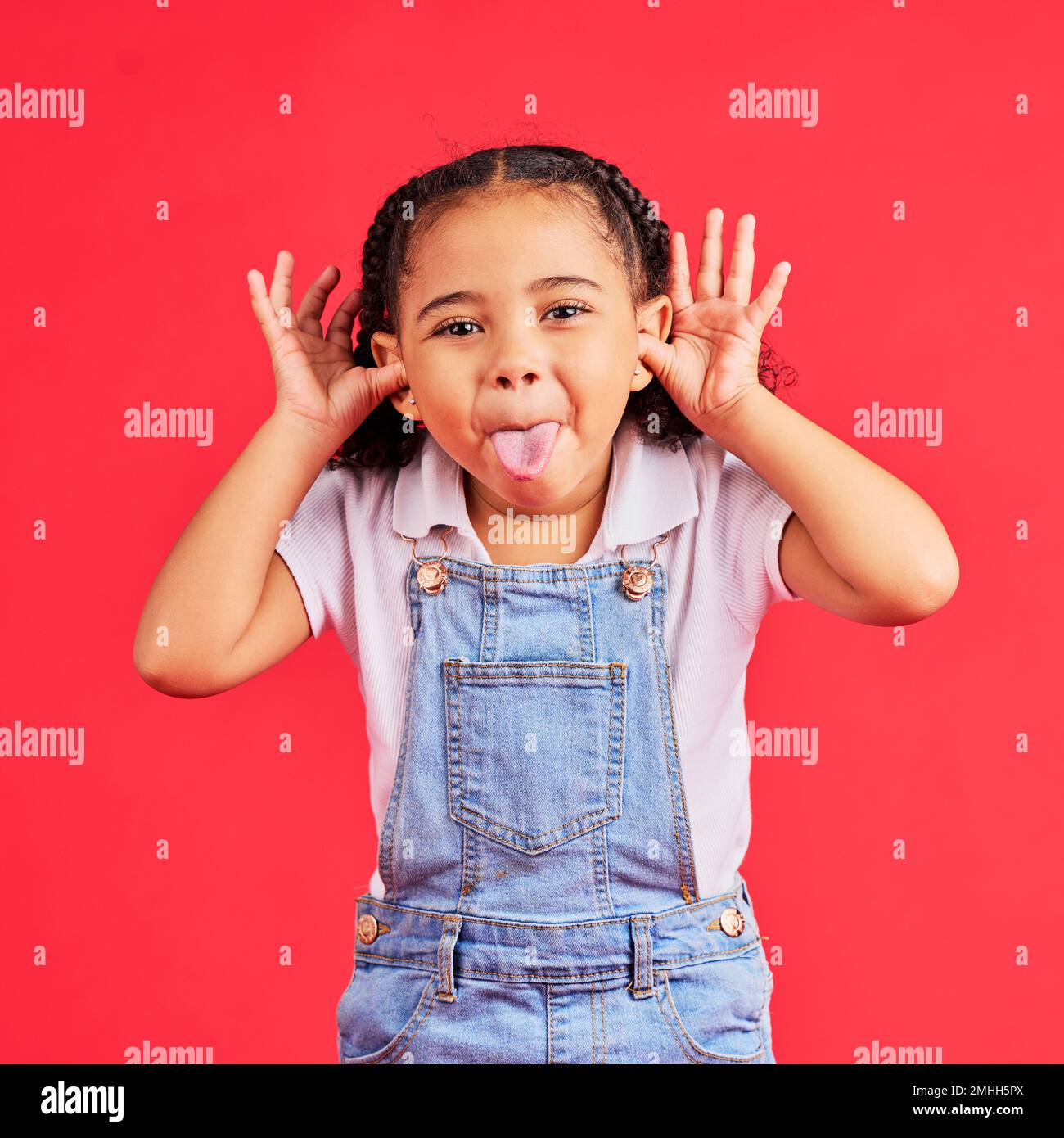 Kind, Porträt und Zunge auf isoliertem roten Hintergrund in albernen, albernen Spielen und verspieltem Gesichtsausdruck. Glücklich, Kind und kleines Mädchen mit lustig Stockfoto