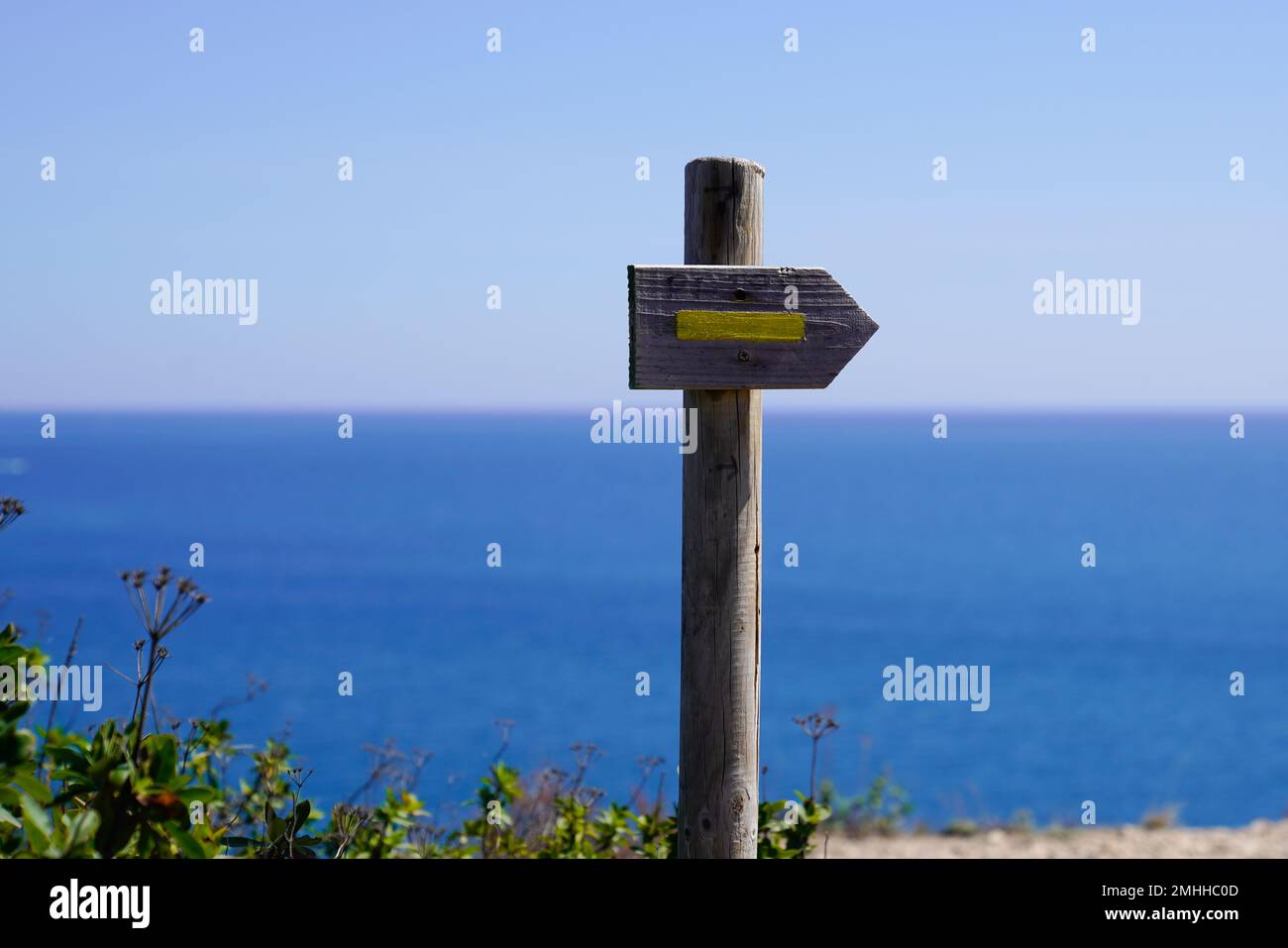 Gelber Holzpfeil, der in Richtung des Fußwegs zeigt, für den Wanderweg beim Ocean Sea Coast Walk Stockfoto