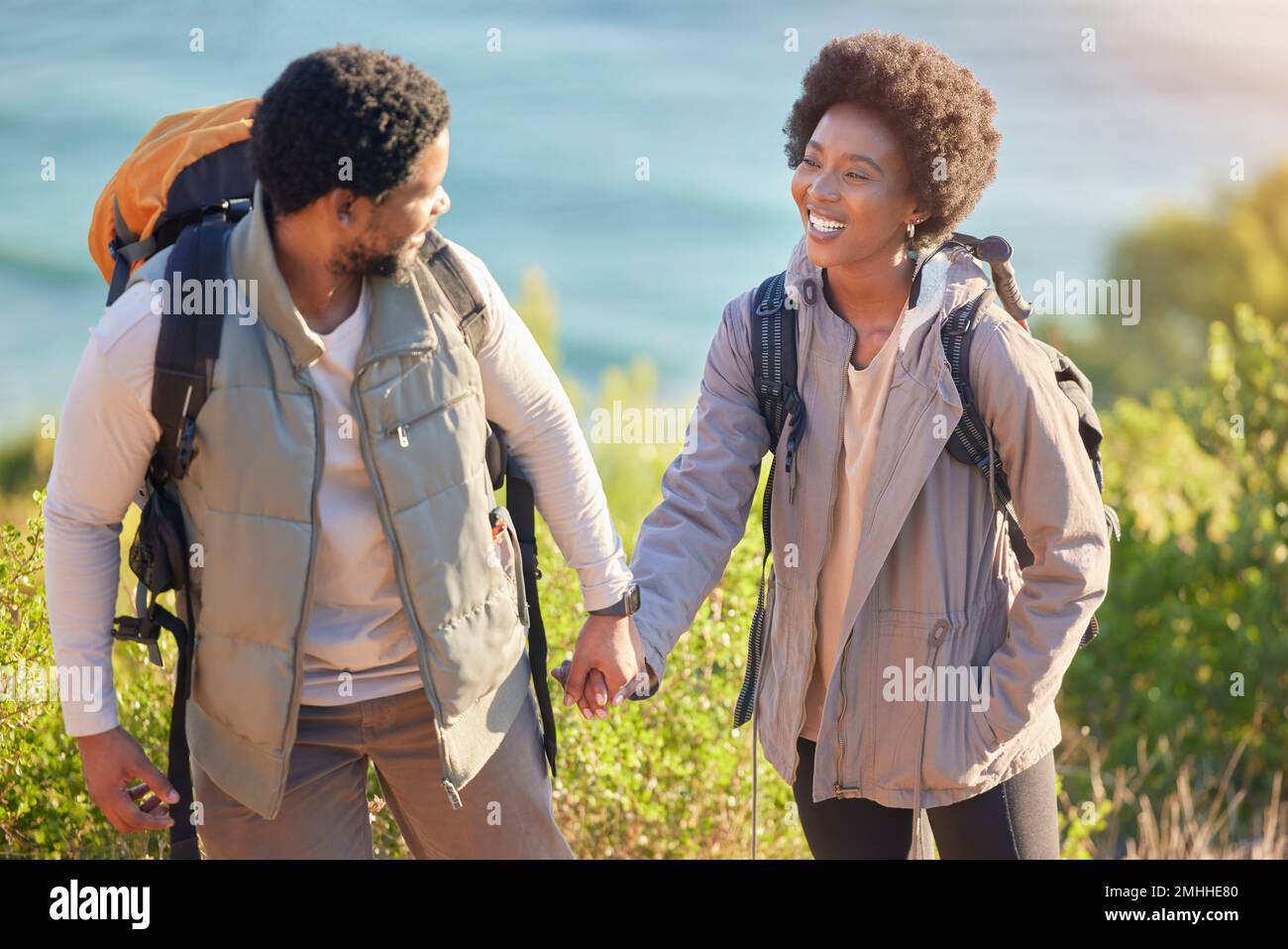 Schwarzes Paar, glücklich und mit Händchen für Wanderungen im Freien, Sightseeing und Zusammensein. Glück, Liebe und Fürsorge für Menschen Stockfoto