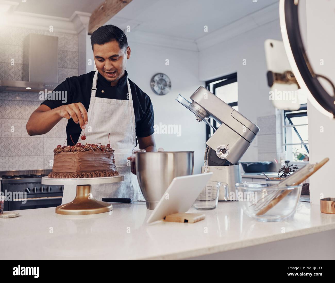 Mann, Vlog und Schokoladenkuchen in der Küche backen, Live-Streaming und Aufzeichnung eines Dessert-Tutorials in sozialen Medien. Alles gute, Koch, Ersteller digitaler Inhalte Stockfoto