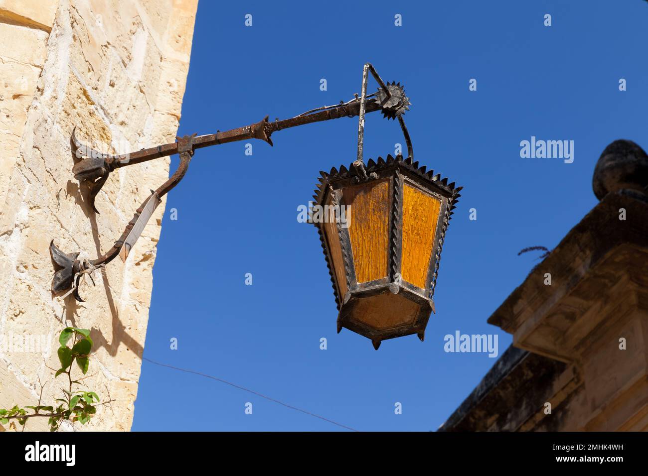 Nahaufnahme der alten Straßenbeleuchtung an einer Wand in Mdina, der befestigten Altstadt von Malta Stockfoto