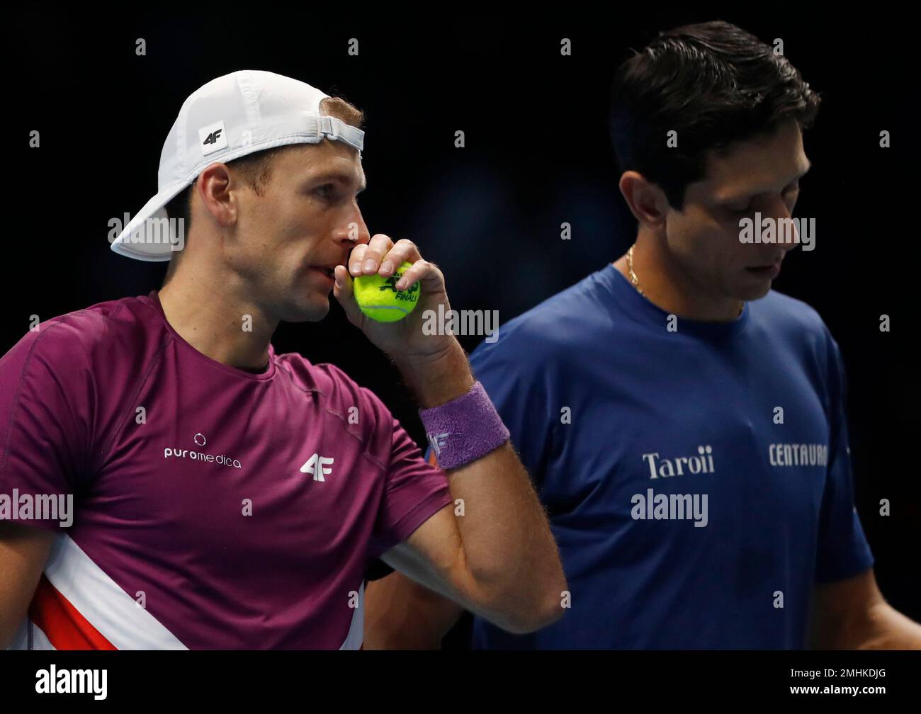 Lukasz Kubot of Poland, left, talk before serving to Ivan Dodig of Croatia and Filip Polasek of Slovakia and Marcelo Melo of Brazil during their ATP World Tour Finals doubles tennis match at the O2 Arena in London, Sunday, Nov. 10, 2019. (AP Photo/Alastair Grant) Stockfoto