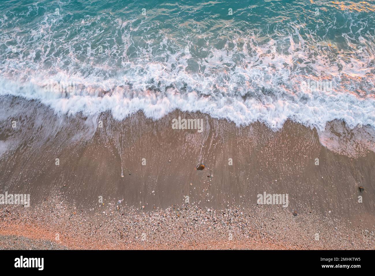 Direkter Blick auf die Wellen und das Ufer kleiner Steine am Bunec Beach im Sommer 2022, Albanien Stockfoto