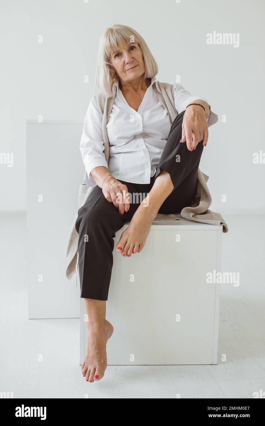 Studioporträt einer grauhaarigen Seniorin. Modefotografie im Studio. Wahrscheinlich ein älteres weibliches Porträt. Stockfoto
