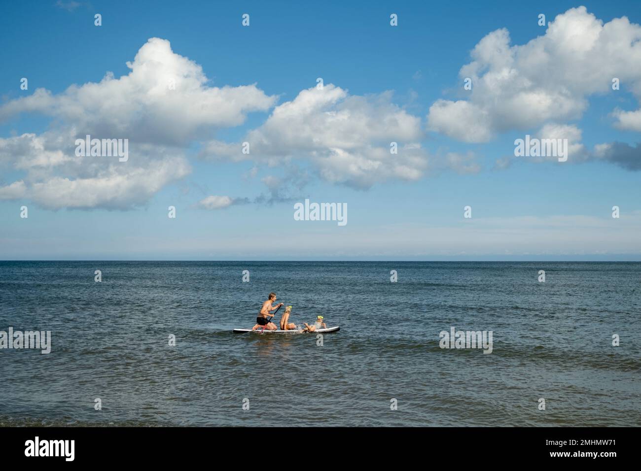 Vater mit Kindern paddelt auf See Stockfoto