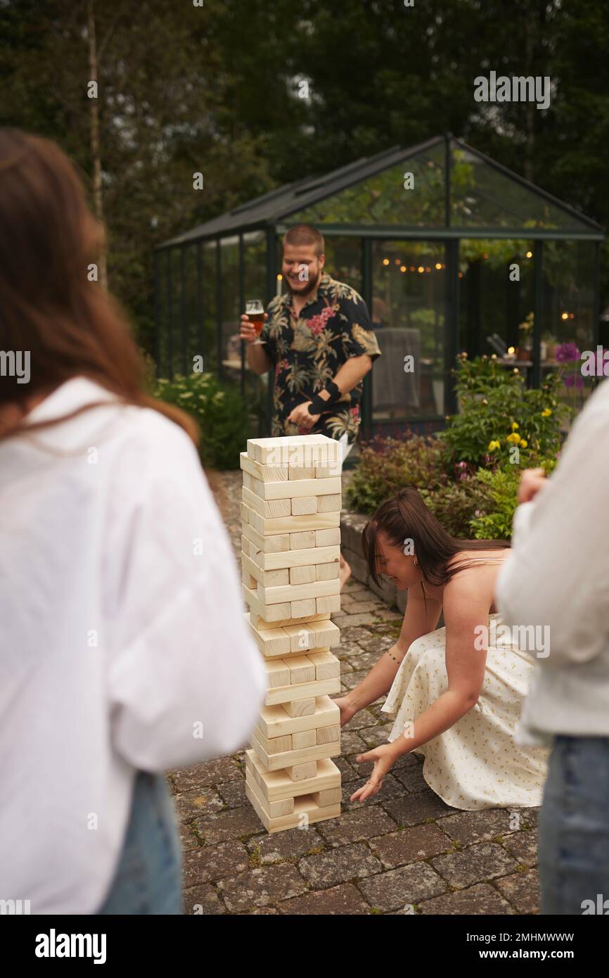 Freunde spielen Riesen-Jenga im Garten Stockfoto