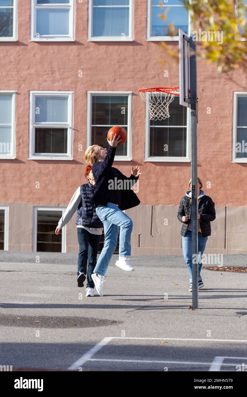 Teenager spielen Basketball auf dem Schulhof Stockfoto
