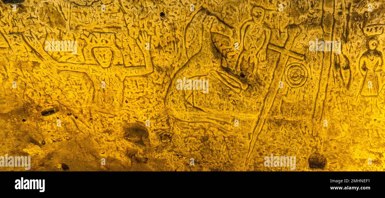 Die Royston Cave in Herfordshire, Großbritannien, verwirrt heute noch Historiker. Die Figur ganz links auf dem Bild mit den erhobenen Armen könnte König David aus dem Buch der Psalmen sein. Royston Cave in Katherine's Yard, Melbourn Street, Royston, England Stockfoto