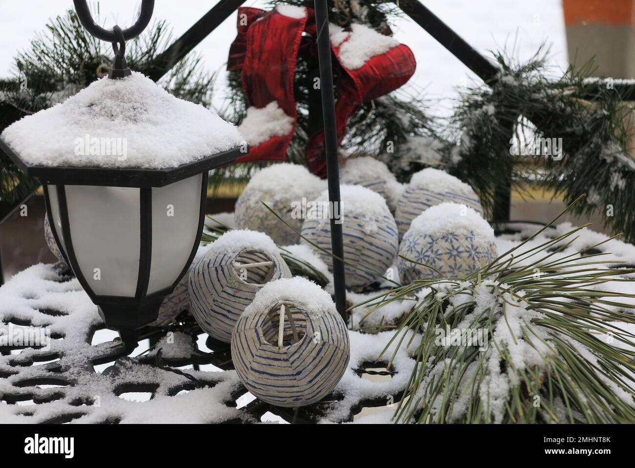 Laterne, Pinienzweige und eine rote Schleife im Schnee zu weihnachten. Bild einer magischen Atmosphäre. Weihnachtsfeiertag. Festliches Winterkonzept. Stockfoto