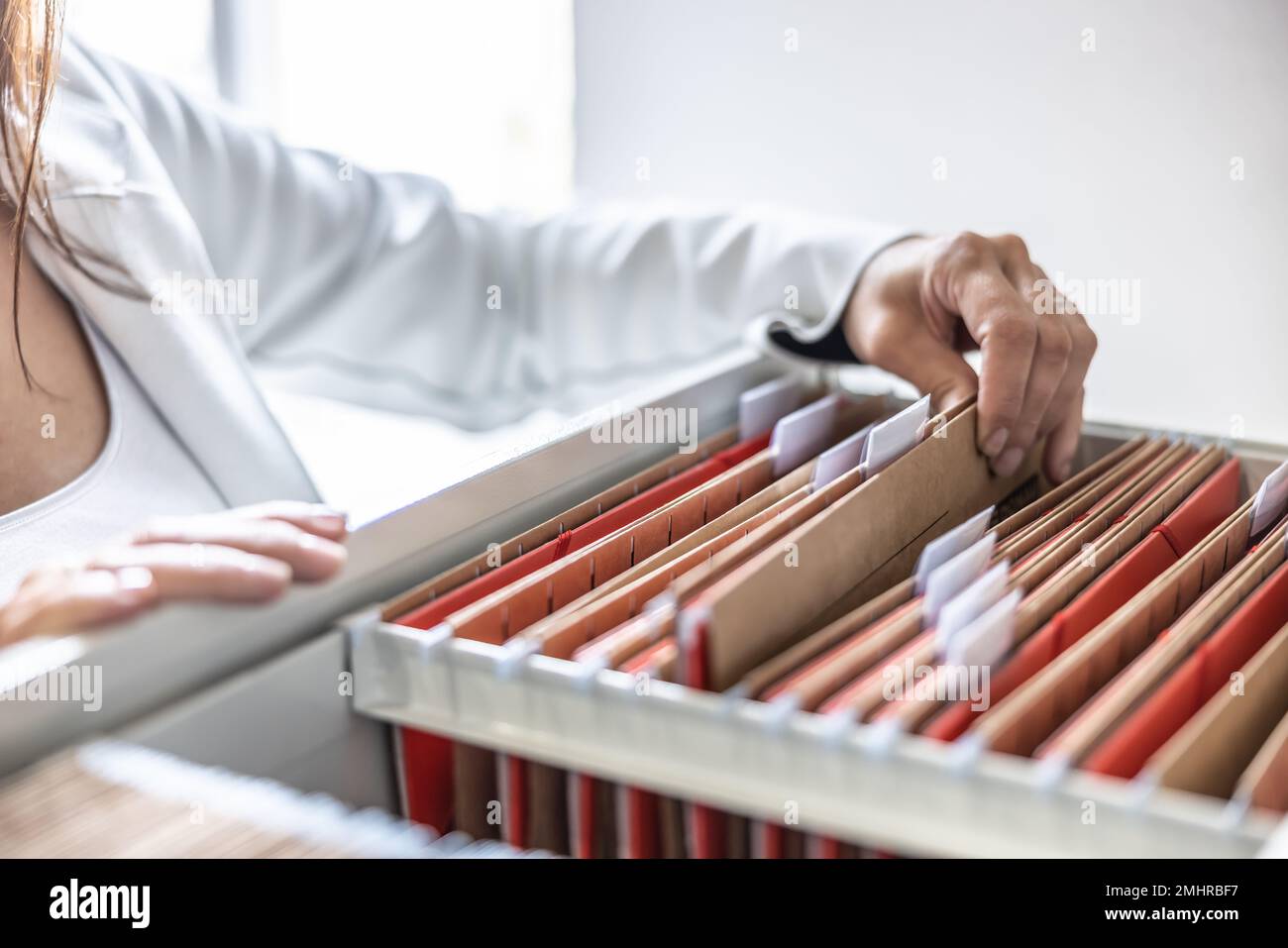 Der Mitarbeiter durchsucht gespeicherte Ordner und sucht nach einer Datei oder einem Dokument. Konzept der Datenspeicherung, Aktenschrank und Betriebsverwaltung. Stockfoto