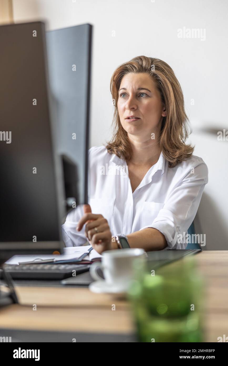 Eine Buchhalterin oder Geschäftsfrau arbeitet in ihrem Büro an einem Computer. Stockfoto