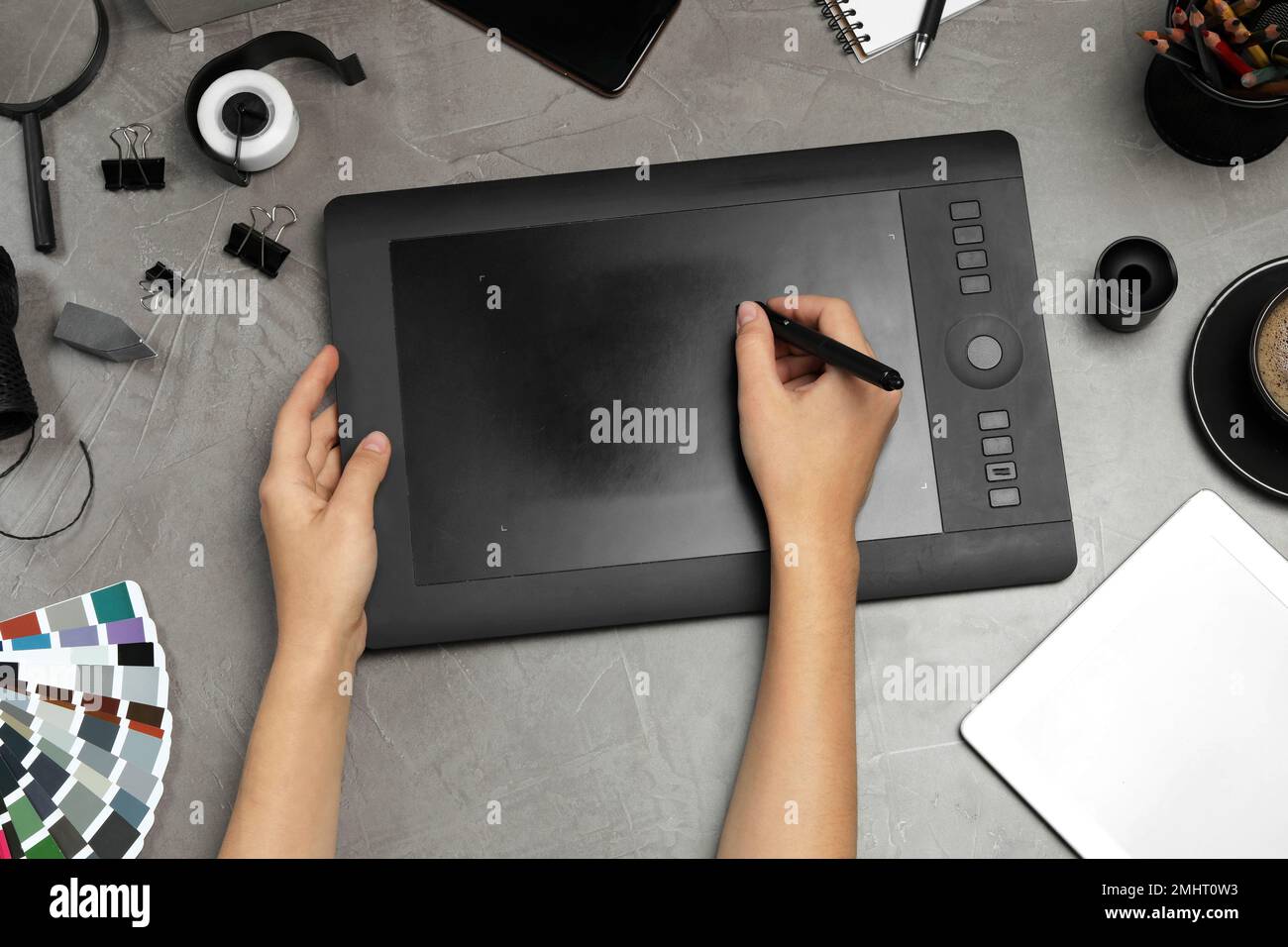 Professionelle Designerzeichnung mit Grafiktablett am Tisch mit grauem Stein, Draufsicht Stockfoto