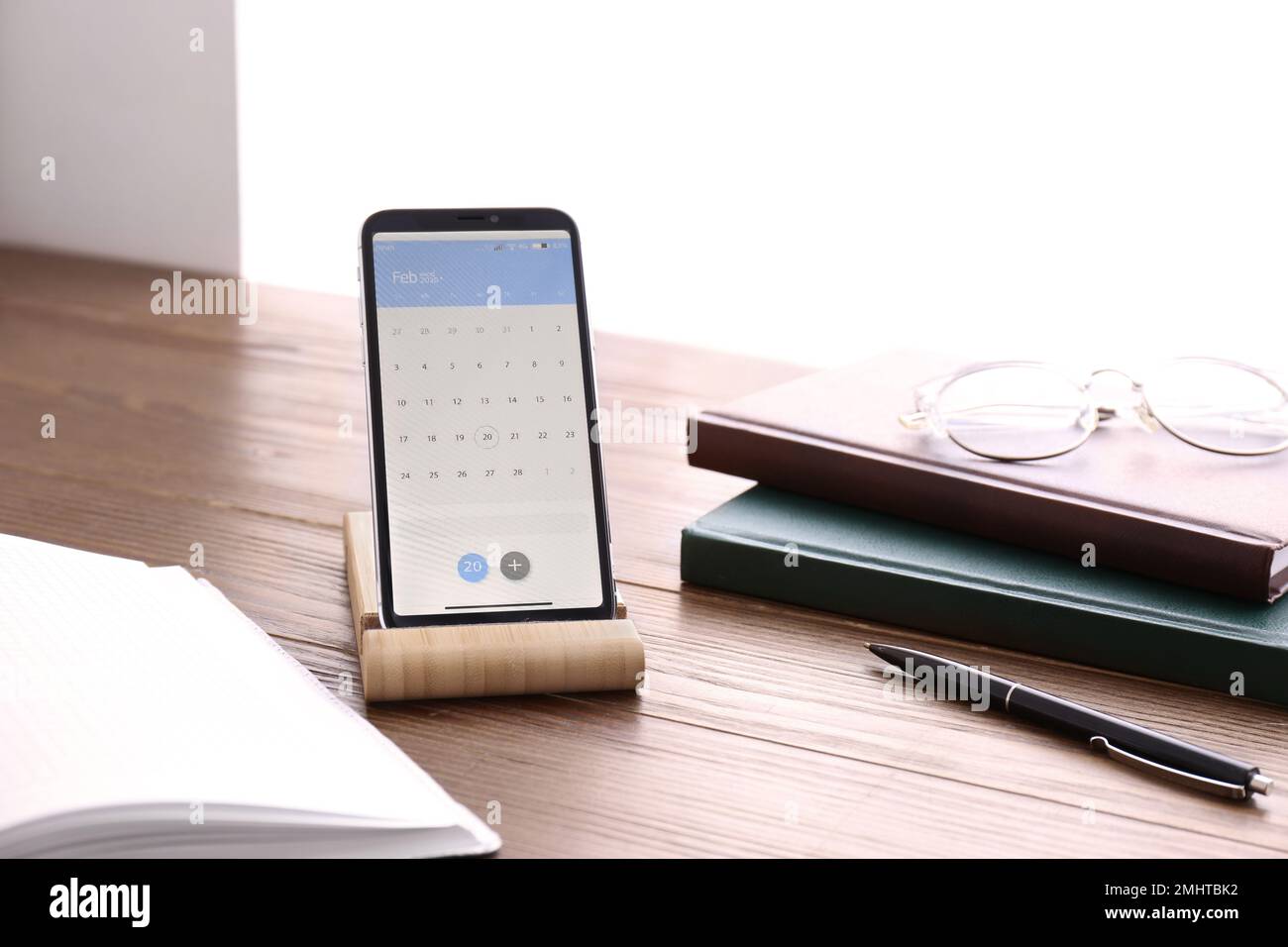 Smartphone mit Kalender-App auf Holztisch Stockfoto