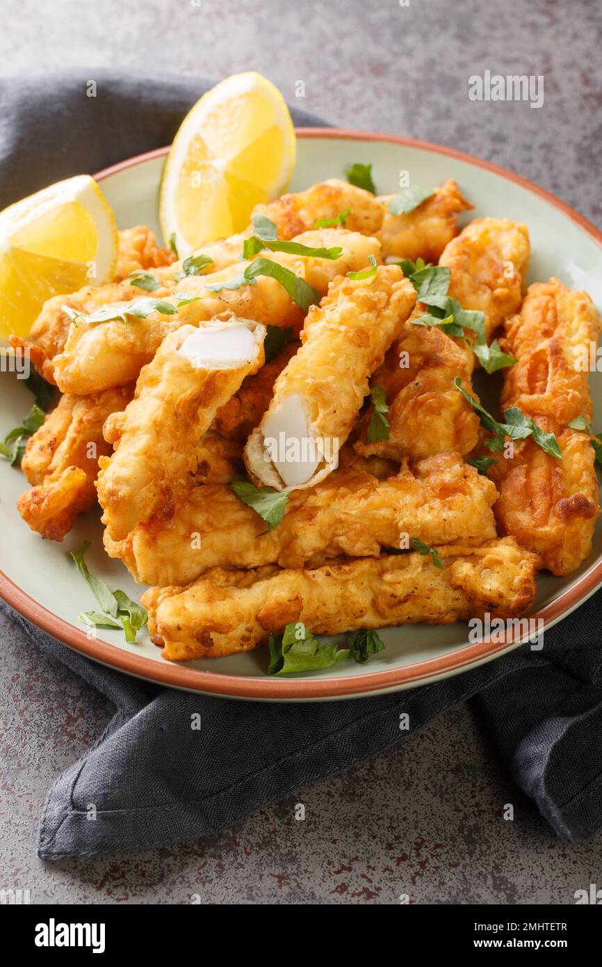 Gebratener spanischer Tintenfisch Rabas Fritas auf dem Teller auf dem Tisch. Vertikal Stockfoto