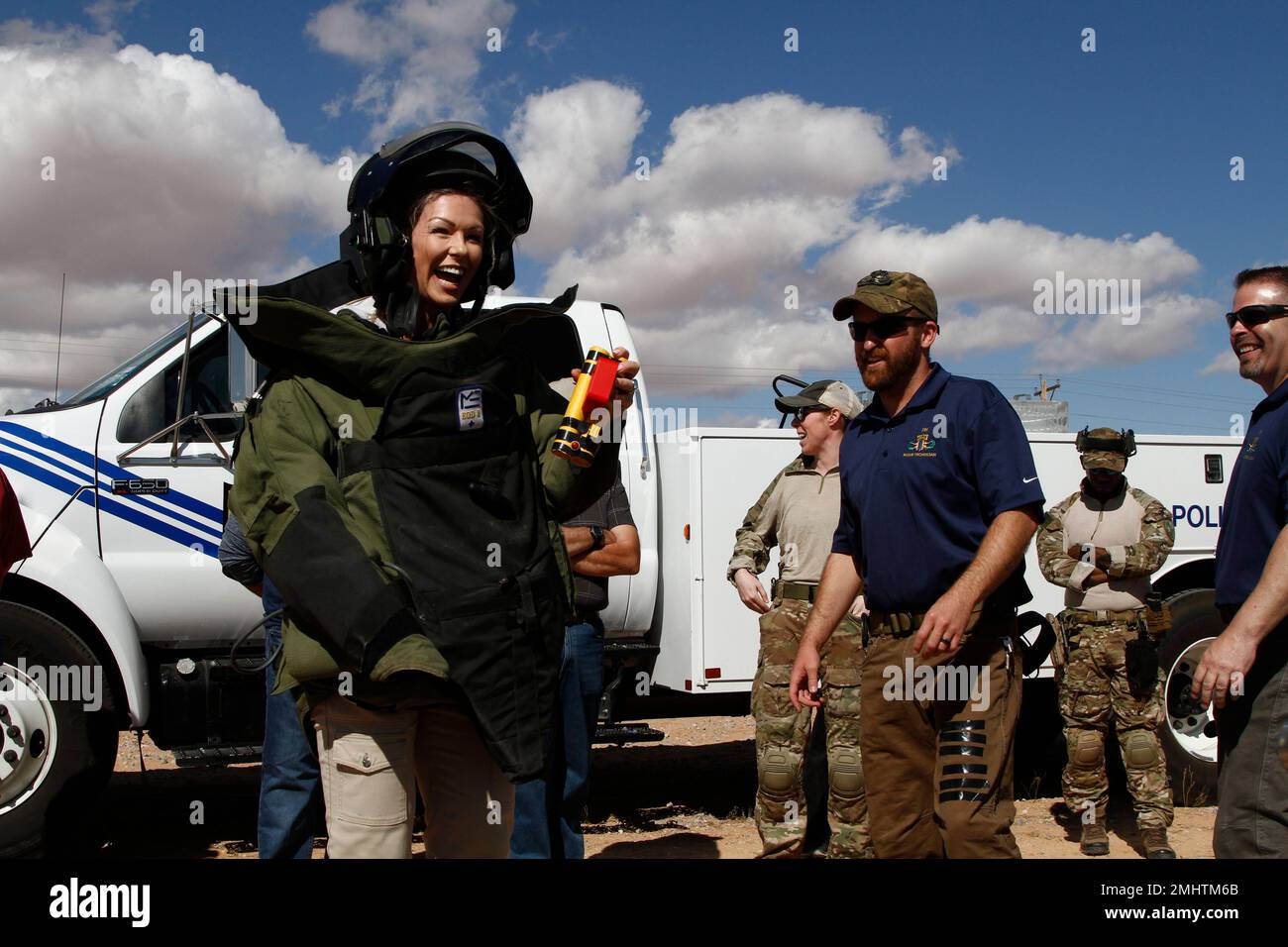 A woman poses for a photo wearing a bomb suit and holding fake explosives during an FBI demonstration on Friday, Oct. 18, 2019, in Otero, New Mexico. The woman is a physical therapist from nearby El Paso, Texas, one of a dozen residents taking part in the FBI's annual "citizen academy." (AP Photo/Cedar Attanasio) Stockfoto