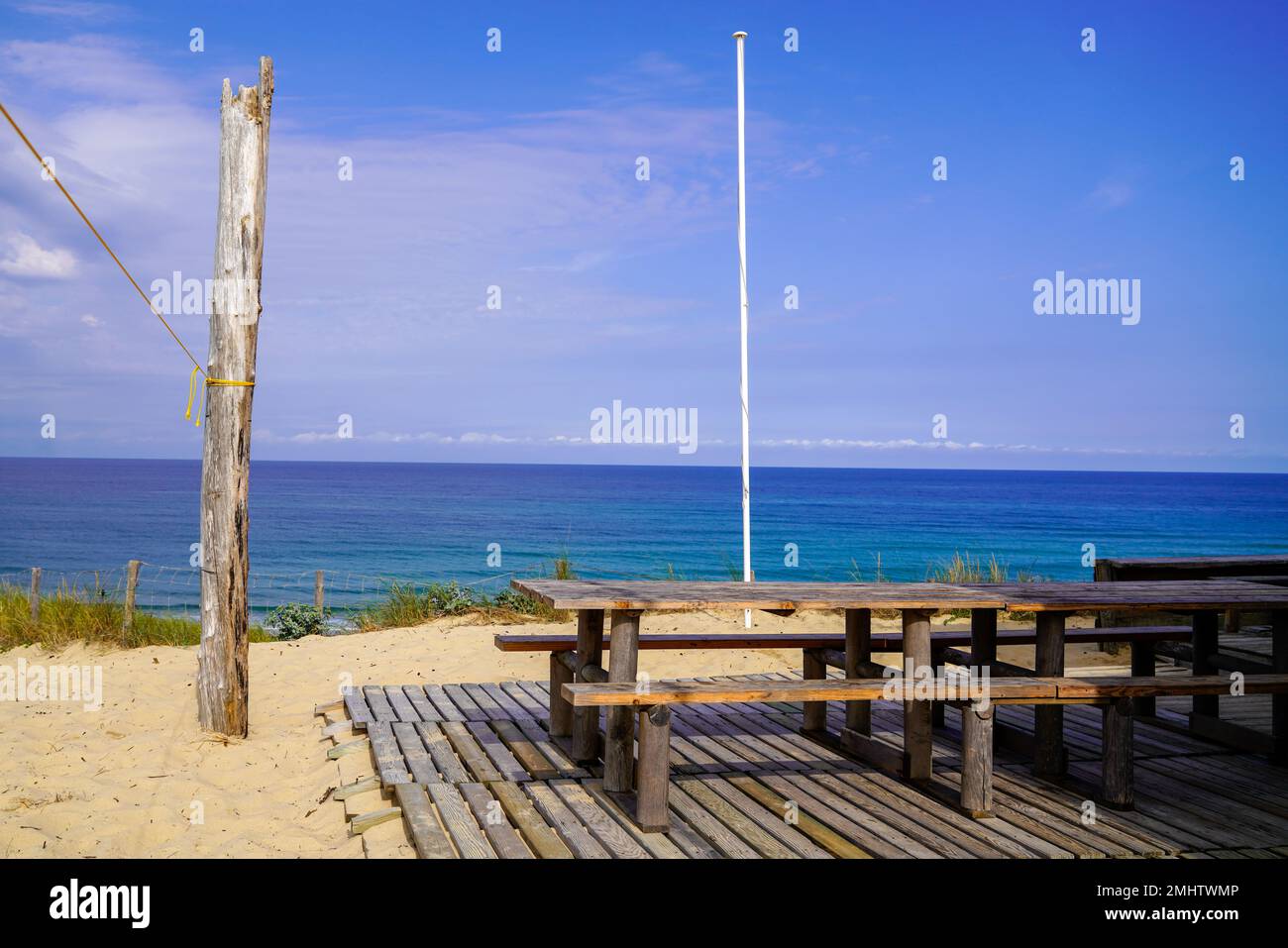 Holzstühle und -Tische sind auf der Holzterrasse des Austernbarrestaurants am Strand in der französischen Bucht arcachon leer Stockfoto