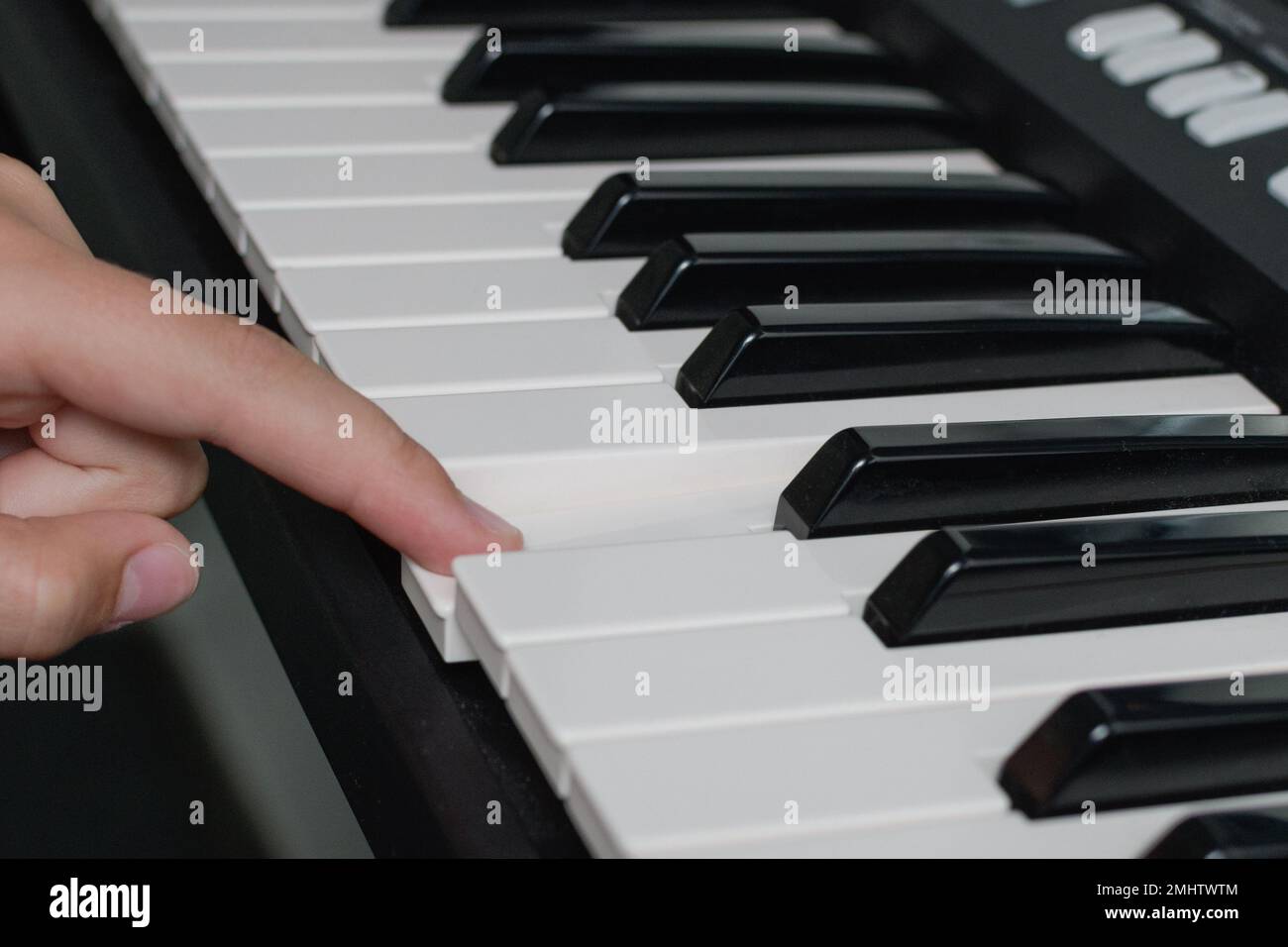 Ein-Finger-Klaviertasten spielen. Musikunterricht. Nahaufnahme der Synthesizer-Tastatur Stockfoto